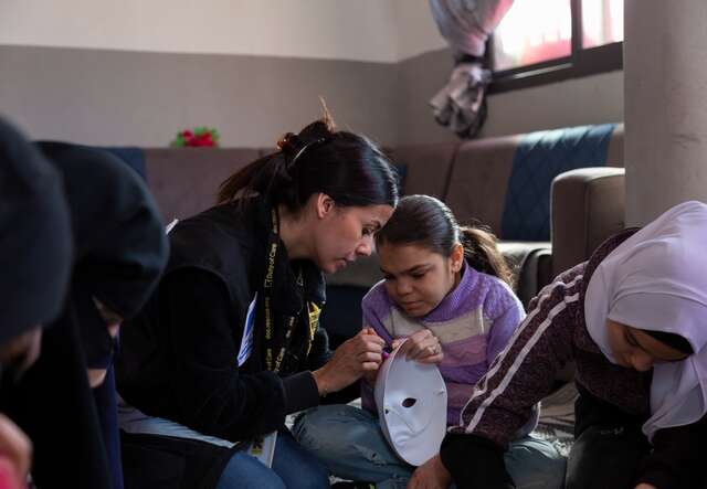 Ameera, a young Syrian refugee, participates in a program at an IRC safe space in Lebanon. An IRC caseworker helps Ameera with her project.