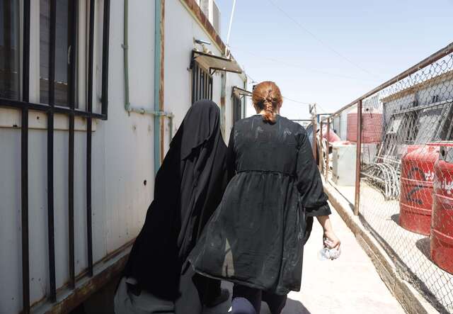 Ebtisam and her psychologist, Ramia, walk together.