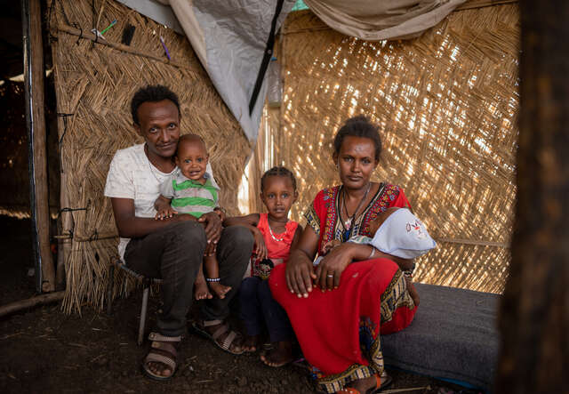 Almas, 29, sits with her family inside their tent in the Gedaref camp. 