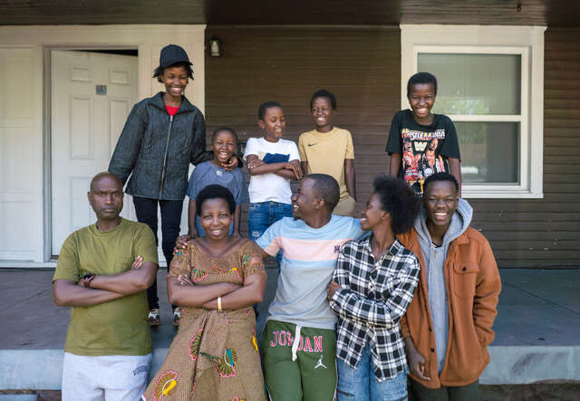 22 year old Bonfils Tuyishime (middle) stands outside his new home with his family in Louisville, Kentucky. 