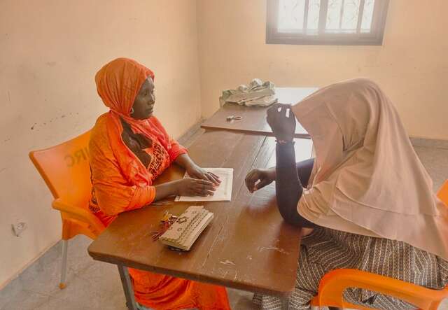 Anima talks to a woman who has survived gender-based violence at the Tenenkou listening center.