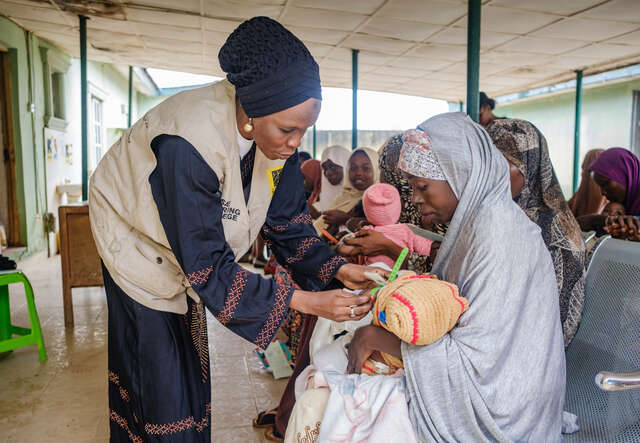 Mothers learn how to use the MUAC to check if their child is malnourished. 