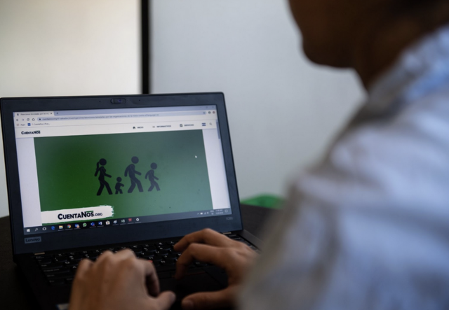 A man typing and looking at the laptop screen