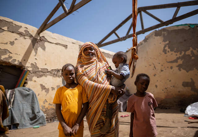 Altuma stands with her three children.