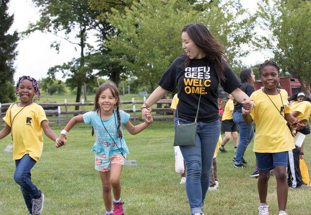 Staff and RYSA students holding hands and playing in the farm.