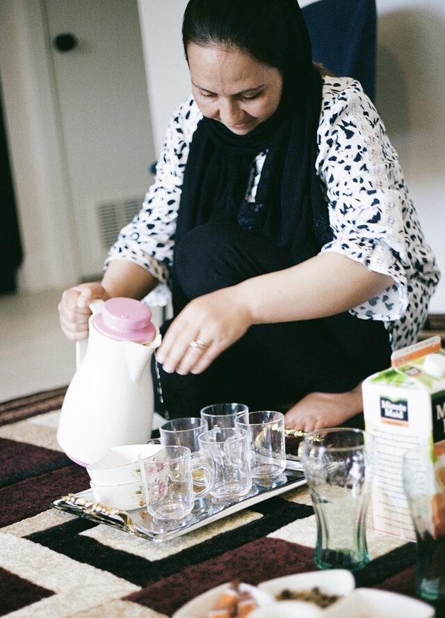 Farzana pouring tea in her home in Salt Lake City.