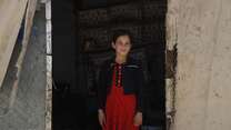 A girl stands in the middle of a doorway in Syria.