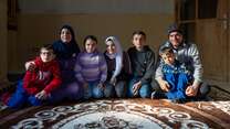 A family of Syrian refugees sit together in their home in Lebanon.