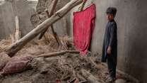 Abas, a twelve year old Afghan boy, stands in the remains of his home which was destroyed by a severe flood.