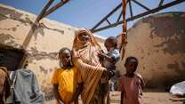 Altuma, 45, and her children stand inside their roofless shelter in Gedaref, Sudan.