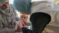 Young child being given fortified peanut paste (RUTF) for malnutrition in Gaza