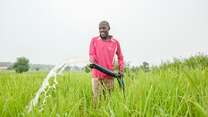 Ein Landwirt verwendet eine Wasserpumpe, um seine Felder im ländlichen Nigeria zu bewässern.