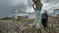 A woman carries firewood on her head in a camp for displaced people in South Sudan