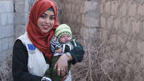 Dr. Bushra holds a baby in Yemen