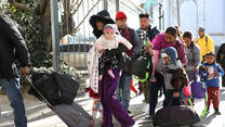 Central American families stand in line, waiting to present themselves to U.S. immigration authorities at the U.S.-Mexico border near Ciudad Juarez, Mexico.