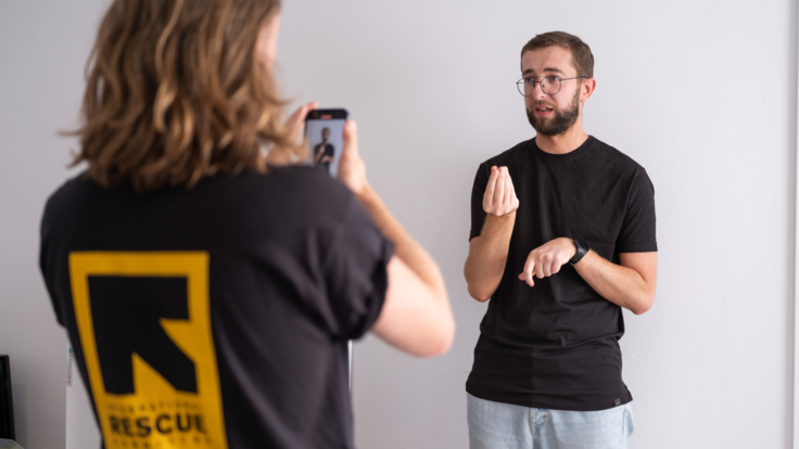 Oleksii stands while an IRC staff member records him.