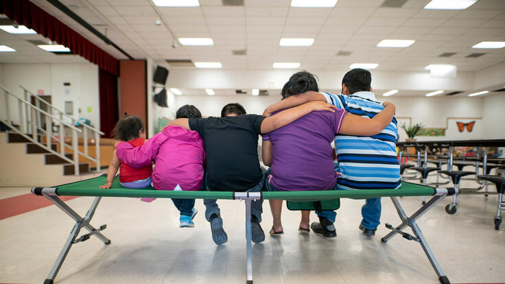 Marta, Julio and their children sit with their backs to the camera.