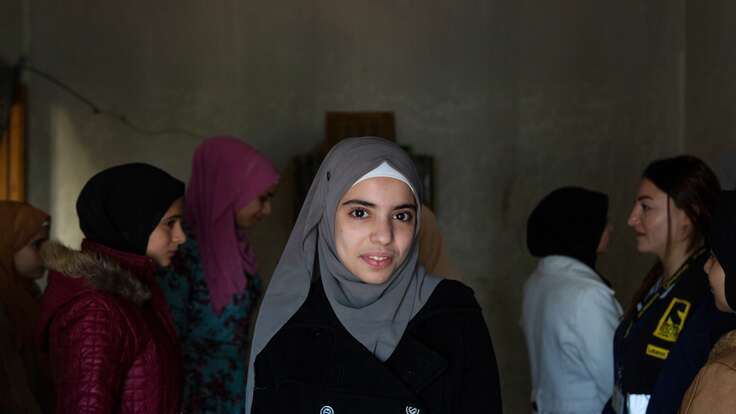A girl poses for a photo at an IRC safe space place for girls in Lebanon.
