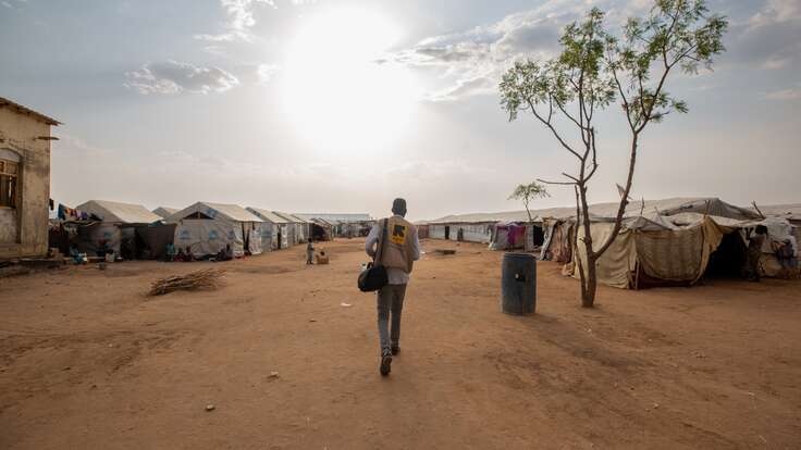 An IRC staff walks towards a camp for displaced people in South Sudan.