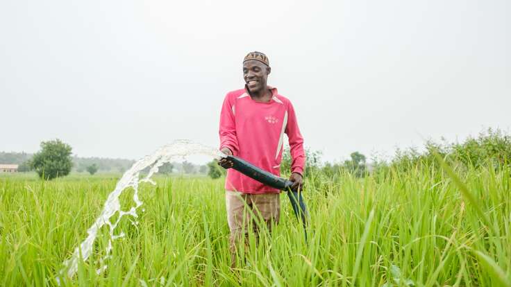 A farmer uses a water pump to irrigates his crops in rural Nigeria.